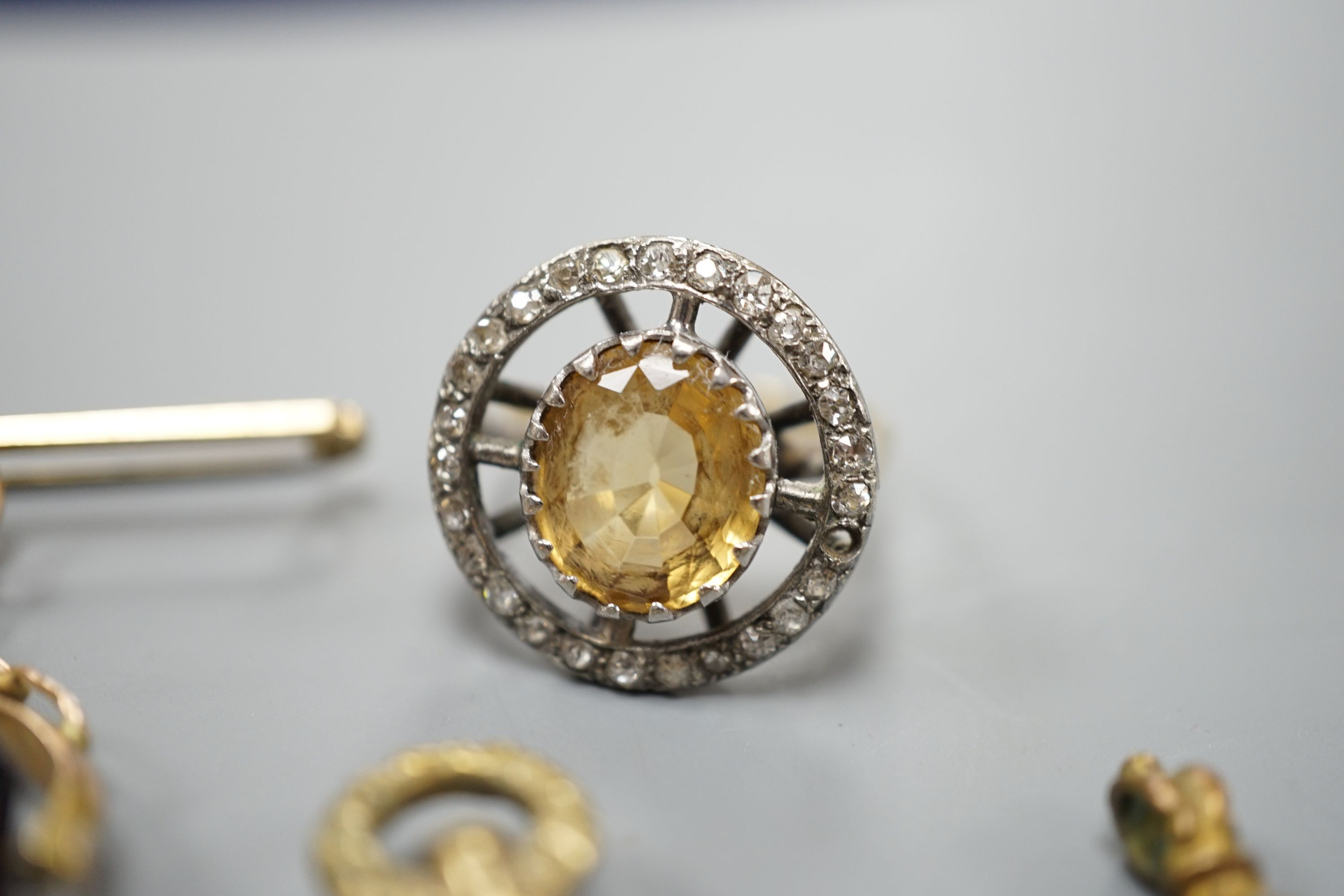 An 18ct, oval cut citrine and round cut diamond set circular cluster dress ring, size R/S, gross 7.1 grams, together with a gem set watch key and two fobs including 9ct brooch suspension.